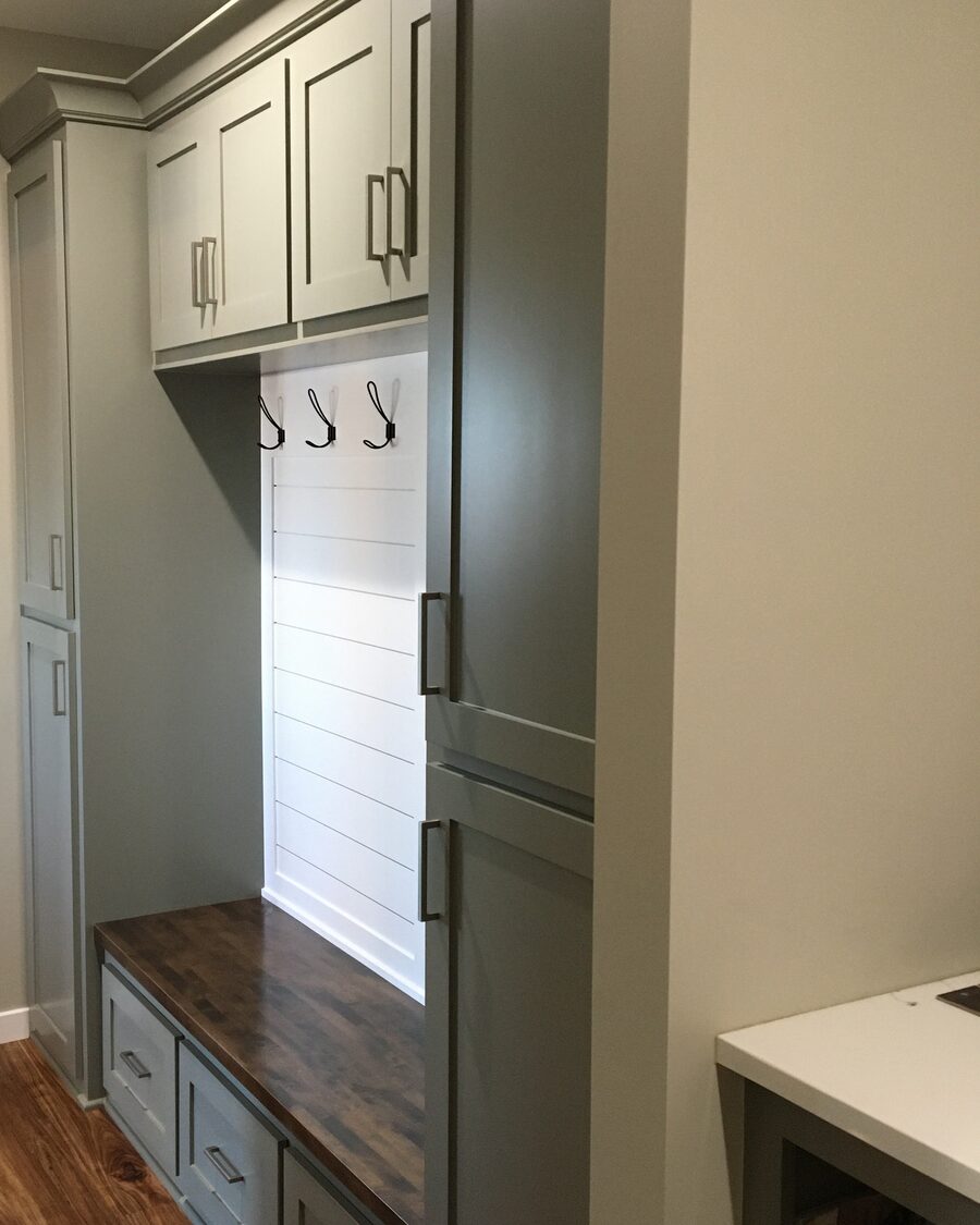 Painted mudroom locker with coat hooks, shiplap back and a stained bench